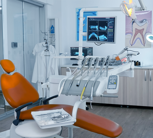 Ortodonzia adulti in un moderno studio dentistico progettato per adulti, con una poltrona arancione, attrezzature dentistiche, immagini a raggi X su un monitor, un disegno di denti su una cartellina e strumenti medici in una stanza pulita e luminosa.