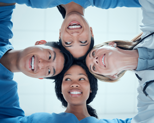 Apparecchio denti bambini con un gruppo di professionisti che formano un cerchio guardando verso l’alto, simbolo di collaborazione e lavoro di squadra