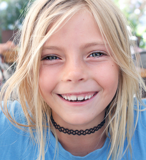 Apparecchio denti bambini con una bambina sorridente con dentizione in sviluppo, ideale per trattamenti con apparecchio denti bambini