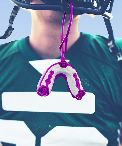 Paradenti bambini per un giovane atleta con casco da football americano che indossa un paradenti per bambini di colore viola
