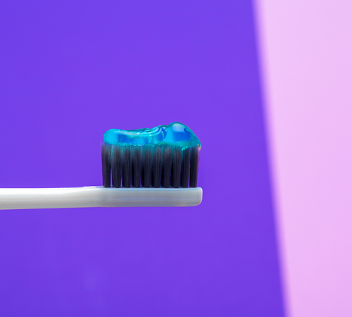 fluoroprofilassi infantile mostra come applicare il dentifricio al fluoro applicato su uno spazzolino.