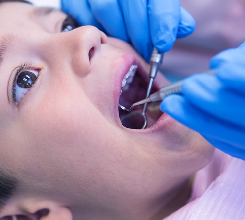curettage dentale bambini mostra un dentista che utilizza strumenti manuali per eseguire un delicato curettage sulla gengiva di un bambino