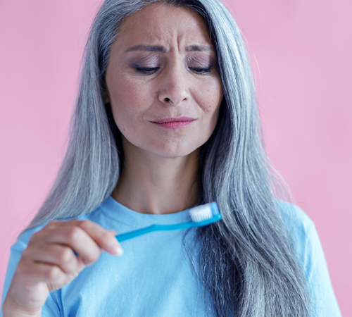 Curettage dentale bambini rappresenta una persona che nota fastidio o dolore durante l’igiene orale