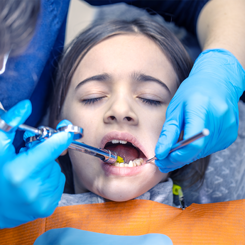 Curettage dentale bambini illustra la procedura odontoiatrica con anestesia locale su un paziente pediatrico