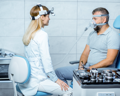 Dispositivi anti-russamento presentano una visita specialistica in cui un paziente adulto indossa una maschera respiratoria mentre la dottoressa esegue un controllo clinico.