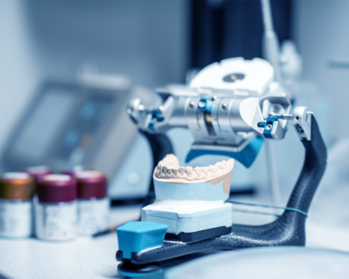 Protesi e chirurgia dentale mostra la fase di preparazione di un modello dentale su articolatore, utilizzato per pianificare protesi e interventi chirurgici con massima precisione.