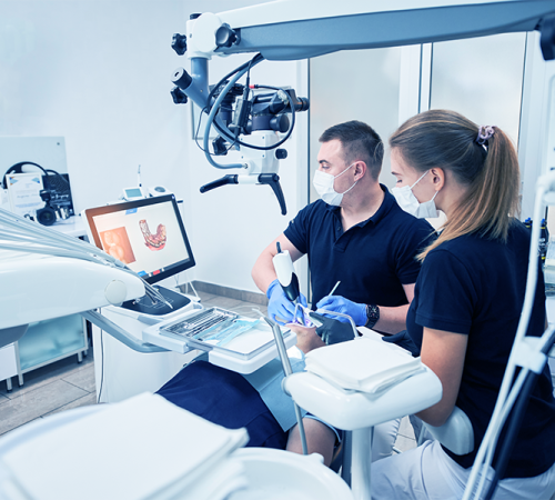 Protesi e chirurgia dentale mostra un’équipe odontoiatrica mentre utilizza strumenti digitali avanzati durante un intervento su un paziente