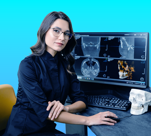 Ricostruzione dentale estetica mostra una specialista che analizza immagini radiografiche e modelli cranio-facciali per pianificare un intervento estetico di ricostruzione dentale