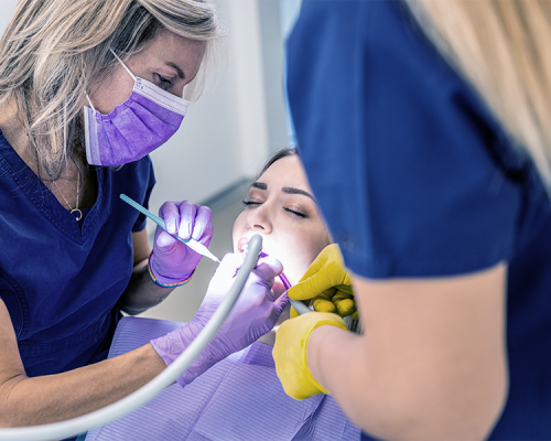 Otturazioni dentali evidenzia una paziente che riceve una cura conservativa mentre l’équipe odontoiatrica illumina e tratta con precisione il dente danneggiato
