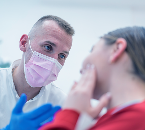 Trauma dentale evidenzia una paziente che indica la parte dolorante del viso mentre parla con il dentista durante la valutazione del trauma orale