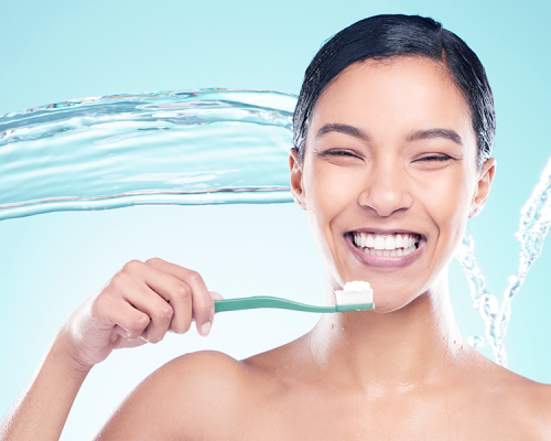 Igiene orale adulti: evidenzia una donna adulta che si lava i denti mostrando un sorriso luminoso e un’ottima igiene quotidiana