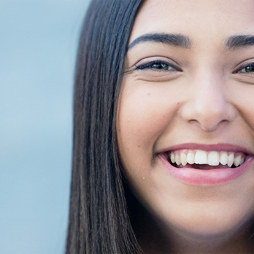 Fluoro profilassi adulti evidenzia il sorriso di una giovane donna con smalto uniforme, risultato dei trattamenti mirati per migliorare denti macchiati o fragili.